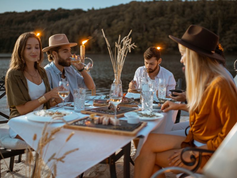 Friends dining on the beach at dusk